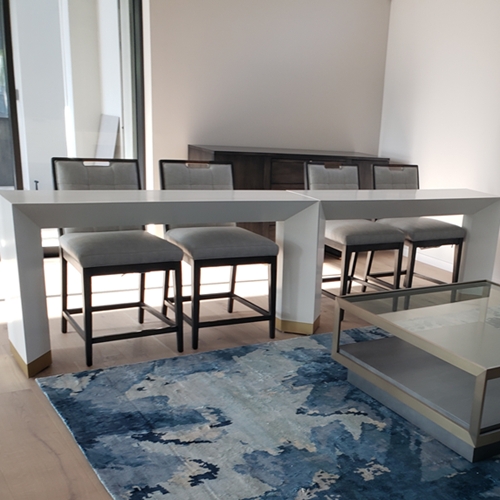 barstools behind table with a blue rug