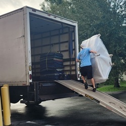 mover carrying sofa wedge up ramp to truck