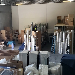 warehouse storage with racks and wrapped furniture and rugs being stored