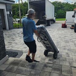 mover using 2-wheeled dolly to carry delicate piece into house
